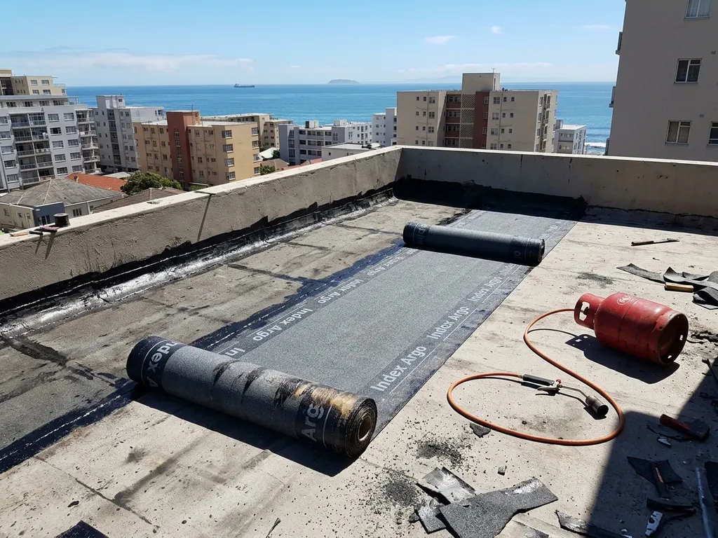 Approved applicator torch-fusing a Derbigum bituminous membrane onto a flat roof in the Cape Town metro
